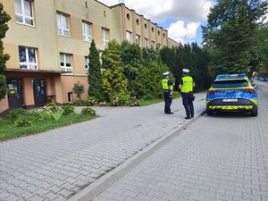 policjanci wokół szkoły dokonują lustracji oznakowania.
