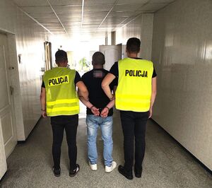 policjanci prowadzą zatrzymanego.
