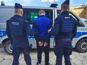 policjanci prowadzą zatrzymanego.