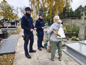 dzielnicowi na cmentarzu rozdają ulotki.