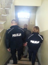 Policjanci prowadzą zatrzymanego