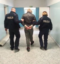 Policjanci prowadzą zatrzymanego