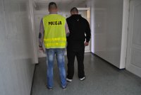 policjant prowadzi zatrzymanego