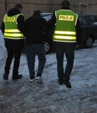 policjanci prowadzą zatrzymanego