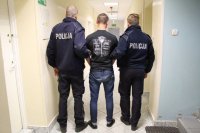 policjanci prowadzą zatrzymanego