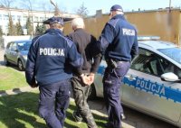 policjanci z zatrzymanym przy radiowozie