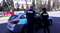 policjanci z zatrzymanym wsiadają do radiowozu